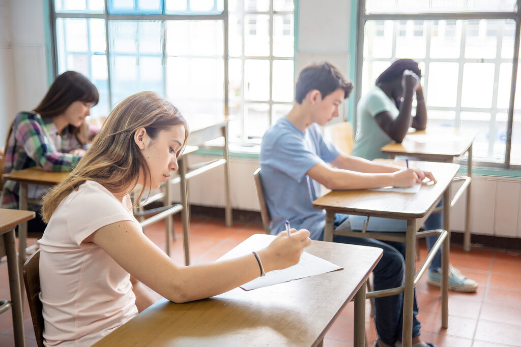Schüler sitzen in einer Klasse und schreiben eine Arbeit